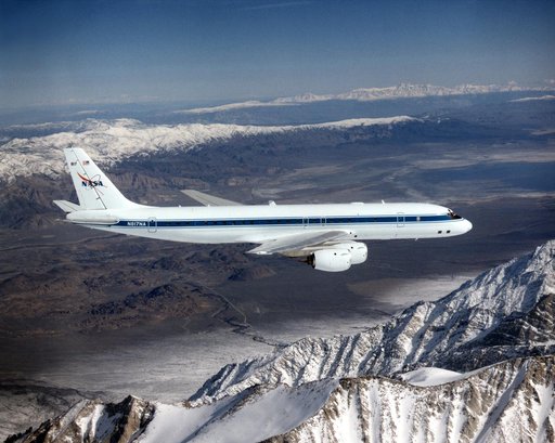 DC-8 Airborne Laboratory in flight over snow-capped Sierra Nevada mountain range