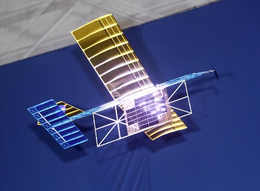 With a laser beam centered on its panel of photovoltaic cells, a model plane makes the first flight of an aircraft powered by a laser beam inside a building at NASA Marshall.