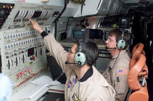 Airborne Science personnel Walter Klein and David Bushman at the Mission Manager's console onboard NASA's DC-8 during the AirSAR 2004 campaign
