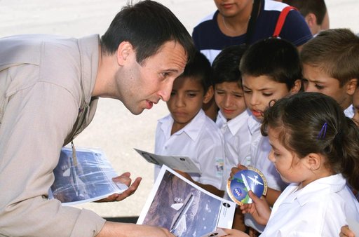 DFRC Mission Manager Walter Klein passes out stickers and lithographs to underprivileged Costa Rican school children that visited the airport on Monday March 8, 2004