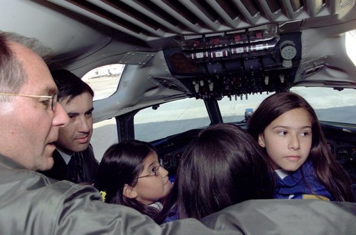 Pilot Bill Brockett (left) and Chilean Air Force Captain Saez with school children in the cockpit of NASA Dryden's DC-8 flying laboratory