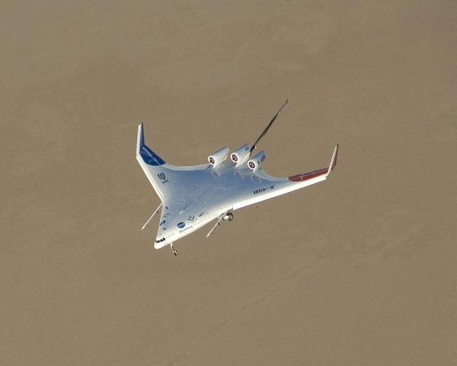 The chocolate-colored expanse of Rogers Dry Lake frames the sleek lines of the Boeing / NASA X-48B subscale demonstrator during a test flight at Edwards AFB