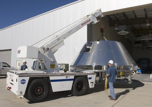 A mockup Orion crew module built by NASA Dryden's Fabrication Branch gets a lift from its construction site to its new home in Dryden's Shuttle hangar.