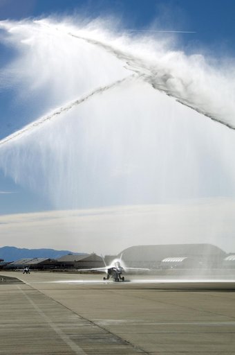 A water-cannon salute from two Air Force fire trucks heralds NASA research pilot Gordon Fullerton's final mission as his NASA F/A-18 taxis beneath the spray.