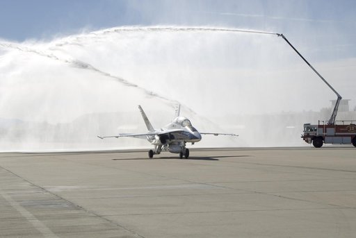 A water-cannon salute from two Air Force fire trucks heralds NASA research pilot Gordon Fullerton's final mission as his NASA F/A-18 taxis beneath the spray.