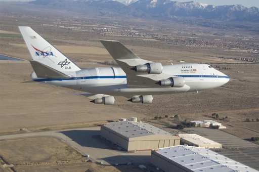 NASA's SOFIA infrared observatory 747SP is shadowed by a NASA F-18 during a flyby at its new home, the Dryden Aircraft Operations Facility in Palmdale, Calif