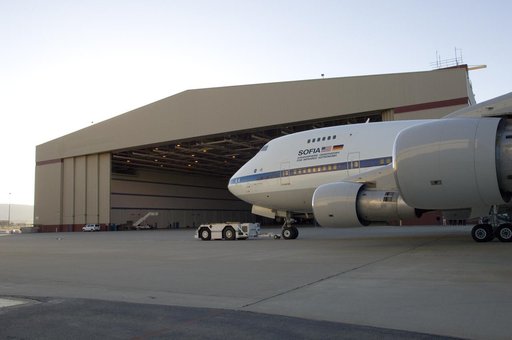 An aircraft tug tows NASA's SOFIA infrared observatory 747SP into Hangar 703 upon arrival at its base, the Dryden Aircraft Operations Facility in Palmdale, CA.