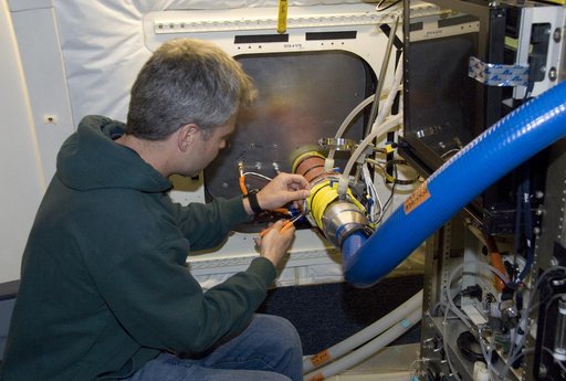 Eric Scheuer of the University of New Hampshire installs the Soluble Acidic Gases and Aerosol instrument in NASA's DC-8 for the ARCTAS mission
