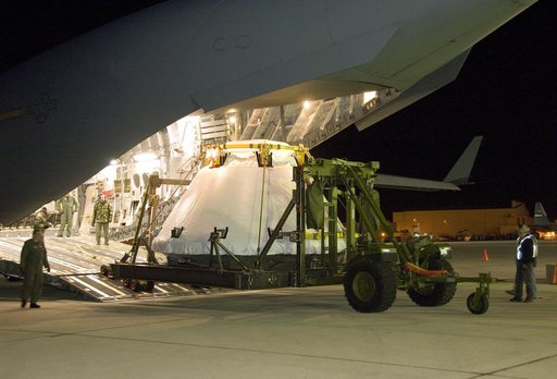 Air Force loadmasters oversee unloading of the full-scale Orion abort test crew module mockup from a C-17 cargo aircraft at Edwards Air Force Base March 28.