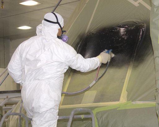 A NASA technician paints NASA's first Orion full-scale abort flight test crew module.