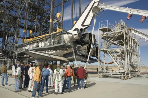 Technicians gather around the rear of Space Shuttle Endeavour for a safety briefing prior to moving the tail workstand around the shuttle's engines
