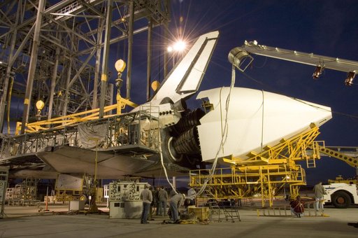 NASA technicians position the aerodynamic tailcone around the engine nozzles of the Space Shuttle Endeavour in preparation for its ferry back to KSC in Florida
