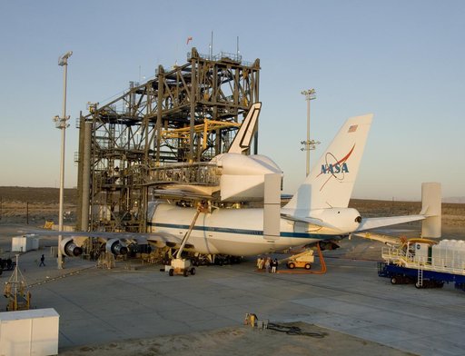 Endeavour and its modified 747 carrier aircraft are illuminated by the morning sun after mating was completed in the Mate-DeMate gantry at NASA DFRC