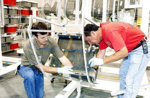 KENNEDY SPACE CENTER, FLA. -  Members of the Columbia Reconstruction Project Team place debris on the mounting fixture for RCC pieces of the leading edge of Columbia’s left wing.   The final shipment of debris arrived on this date - recovery efforts have been concluded in East Texas.  Prior to this 