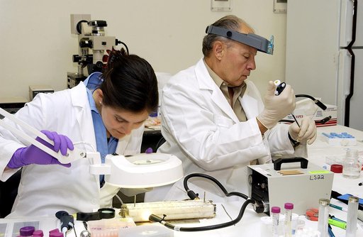 KENNEDY SPACE CENTER, FLA. -  From left, Valerie Cassanto, Instrumentation Technology Associates, Inc., and Dr. Dennis Morrison, NASA Johnson Space Center, analyze one of the experiments carried on mission STS-107. Several experiments were found during the search for Columbia debris. Included in the