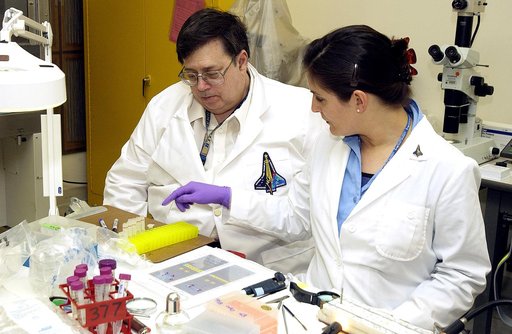 KENNEDY SPACE CENTER, FLA. -  From left, Barry Perlman, Pembroke Pines Charter Middle School in Florida, and Valerie Cassanto, Instrumentation Technology Associates, Inc., process one of the experiments carried on mission STS-107. Several experiments were found during the search for Columbia debris.