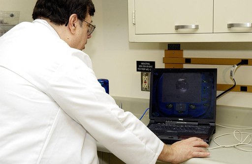 KENNEDY SPACE CENTER, FLA. -  Barry Perlman, Pembroke Pines Charter Middle School in Florida, prepares a computer to receive data from an experiment carried on mission STS-107. Several experiments were found during the search for Columbia debris. Included in the Commercial ITA Biomedical Experiments