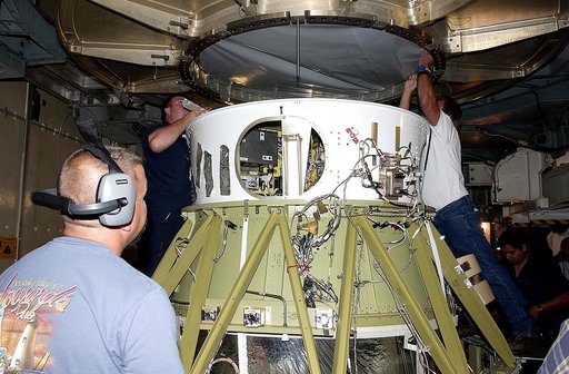KENNEDY SPACE CENTER, FLA. -  Workers on Launch Complex 17-B, Cape Canaveral Air Force Station, start dismantling the Space Infrared Telescope Facility (SIRTF) observatory from atop the Delta II rocket.  It will be taken back to NASA Spacecraft Hangar AE. SIRTF will remain in the clean room at Hanga