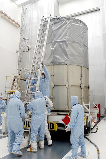 KENNEDY SPACE CENTER, FLA. -  Workers in NASA Spacecraft Hangar AE erect a ladder to reach the top of the Space Infrared Telescope Facility (SIRTF), which has been returned to the hangar from the launch pad.   SIRTF will remain in the clean room until it returns to the pad in early August.  One of N