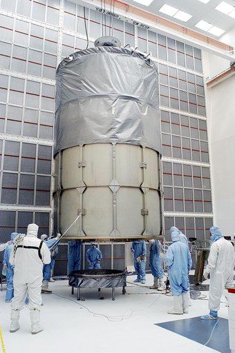 KENNEDY SPACE CENTER, FLA. -  Workers in NASA Spacecraft Hangar AE prepare to remove the canister from around the Space Infrared Telescope Facility (SIRTF), which has been returned to the hangar from the launch pad.   SIRTF will remain in the clean room until it returns to the pad in early August. O