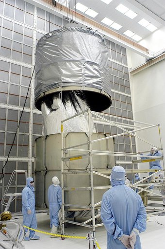 KENNEDY SPACE CENTER, FLA. -  Workers in NASA Spacecraft Hangar AE remove a portion of a transportation canister from around the Space Infrared Telescope Facility (SIRTF), which has been returned to the hangar from the launch pad.   SIRTF will remain in the clean room until it returns to the pad in 