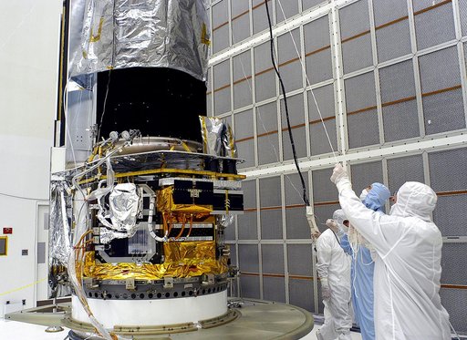 KENNEDY SPACE CENTER, FLA. -  Workers in NASA Spacecraft Hangar AE lift the protective cover from around the Space Infrared Telescope Facility (SIRTF), which has been returned to the hangar from the launch pad.   SIRTF will remain in the clean room until it returns to the pad in early August. One of