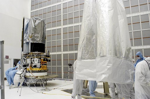 KENNEDY SPACE CENTER, FLA. -  Workers in NASA Spacecraft Hangar AE remove the protective cover from around the Space Infrared Telescope Facility (SIRTF), which has been returned to the hangar from the launch pad.   SIRTF will remain in the clean room until it returns to the pad in early August. One 
