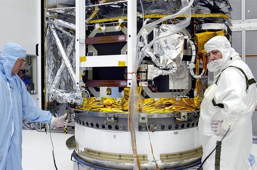 KENNEDY SPACE CENTER, FLA. -  Workers in NASA Spacecraft Hangar AE begin the next phase of processing of the Space Infrared Telescope Facility (SIRTF), which has been returned to the hangar from the launch pad. SIRTF will remain in the clean room until it returns to the pad in early August. One of N