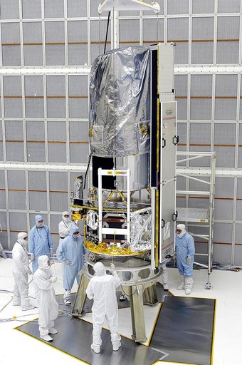 KENNEDY SPACE CENTER, FLA. -  Workers in NASA Spacecraft Hangar AE position the Space Infrared Telescope Facility (SIRTF), which has been returned to the hangar from the launch pad, for further processing. SIRTF will remain in the clean room until it returns to the pad in early August. One of NASA's