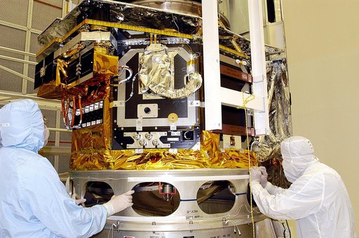 KENNEDY SPACE CENTER, FLA. -  Workers in NASA Spacecraft Hangar AE check the placement of the Space Infrared Telescope Facility (SIRTF), which has been returned to the hangar from the launch pad for further processing. SIRTF will remain in the clean room until it returns to the pad in early August. 