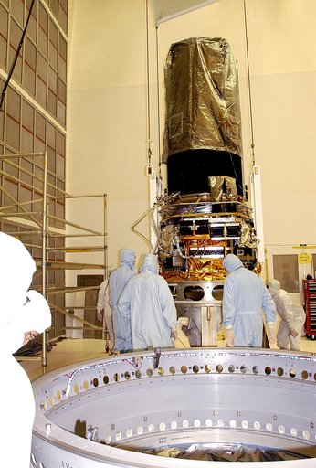 KENNEDY SPACE CENTER, FLA. -  Workers in NASA Spacecraft Hangar AE check the placement of the Space Infrared Telescope Facility (SIRTF), which has been returned to the hangar from the launch pad for further processing. SIRTF will remain in the clean room until it returns to the pad in early August. 