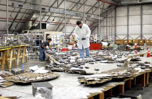 KENNEDY SPACE CENTER, FLA. -  Members of the Columbia Reconstruction Project Team place pieces of debris on a table in the RLV Hangar.   The items shipped to KSC number more than 82,000 and weigh 84,800 pounds or 38 percent of the total dry weight of Columbia.  Of those items, 78,760 have been ident