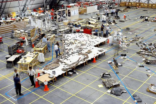 KENNEDY SPACE CENTER, FLA. -  In the RLV hangar, members of the Columbia Reconstruction Team work to identify pieces of Thermal Protection System tile from the left wing of Columbia recovered during the search and recovery efforts in East Texas.  The items shipped to KSC number more than 82,000 and 