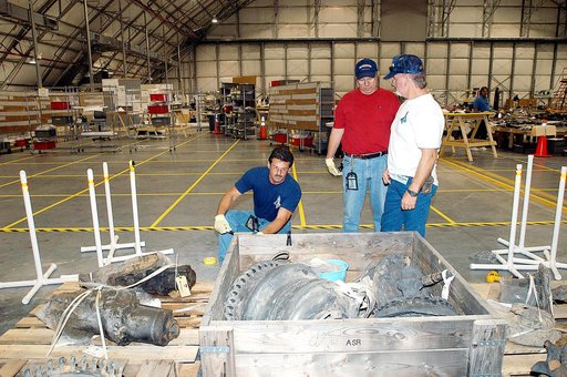 KENNEDY SPACE CENTER, FLA. -  Members of the Columbia Reconstruction Project Team work with pieces of debris in the RLV Hangar. The items shipped to KSC number more than 82,000 and weigh 84,800 pounds or 38 percent of the total dry weight of Columbia. Of those items, 78,760 have been identified, wit