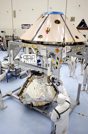 KENNEDY SPACE CENTER, FLA. - Workers in the Payload Hazardous Servicing Facility guide the backshell being lowered over the Mars Exploration Rover 1 (MER-1).  The backshell is a protective cover for the rover.  NASA's twin Mars Exploration Rovers are designed to study the history of water on Mars. T