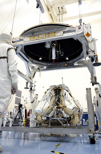 KENNEDY SPACE CENTER, FLA. - Workers in the Payload Hazardous Servicing Facility lower the backshell over the Mars Exploration Rover 1 (MER-1).  The backshell is a protective cover for the rover.  NASA's twin Mars Exploration Rovers are designed to study the history of water on Mars. These robotic g