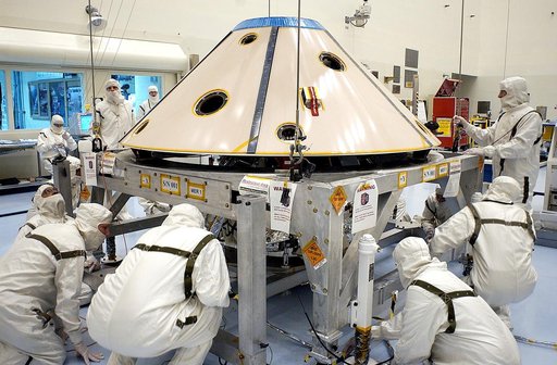 KENNEDY SPACE CENTER, FLA. - Workers in the Payload Hazardous Servicing Facility check the placement of the backshell over the Mars Exploration Rover 1 (MER-1).  The backshell is a protective cover for the rover.  NASA's twin Mars Exploration Rovers are designed to study the history of water on Mars
