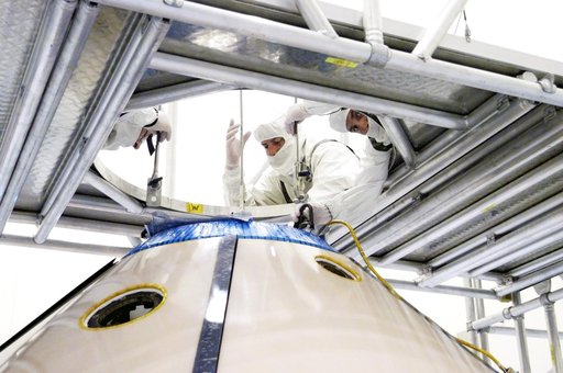 KENNEDY SPACE CENTER, FLA. -  Workers attach an overhead crane to the Mars Exploration Rover 1 (MER-1) inside the upper backshell.   The backshell will be moved and attached to the lower heat shield.  NASA's twin Mars Exploration Rovers are designed to study the history of water on Mars. These robot