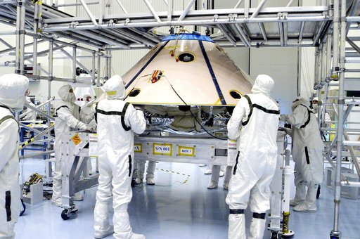 KENNEDY SPACE CENTER, FLA. -  Workers watch as an overhead crane begins to lift the backshell with the Mars Exploration Rover 1 (MER-1) inside.  The backshell will be moved and attached to the lower heat shield.  NASA's twin Mars Exploration Rovers are designed to study the history of water on Mars.