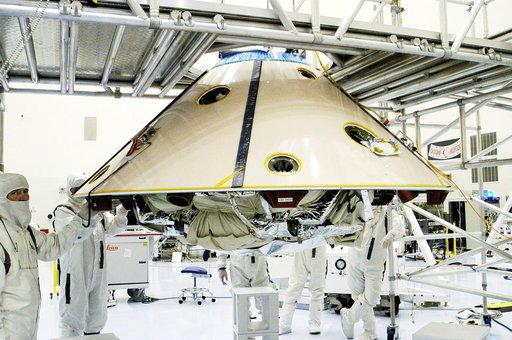 KENNEDY SPACE CENTER, FLA. - Workers walk with the suspended backshell/ Mars Exploration Rover 1 (MER-1) as it travels across the floor of the Payload Hazardous Servicing Facility.  The backshell will be attached to the lower heat shield.  NASA's twin Mars Exploration Rovers are designed to study th