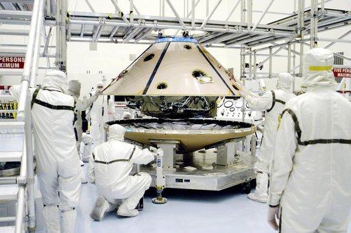 KENNEDY SPACE CENTER, FLA. - In the Payload Hazardous Servicing Facility, workers lower the backshell with the Mars Exploration Rover 1 (MER-1) onto the heat shield.  The two components form the aeroshell that will protect the rover on its journey to Mars.  NASA's twin Mars Exploration Rovers are de