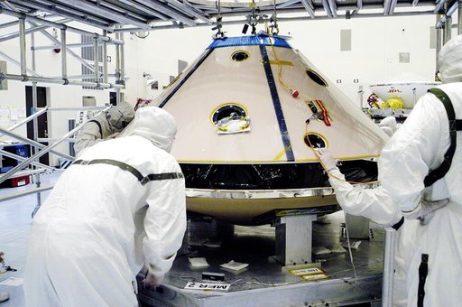 KENNEDY SPACE CENTER, FLA. - In the Payload Hazardous Servicing Facility, workers lower the backshell with the Mars Exploration Rover 1 (MER-1) onto the heat shield.  The two components form the aeroshell that will protect the rover on its journey to Mars.  NASA's twin Mars Exploration Rovers are de