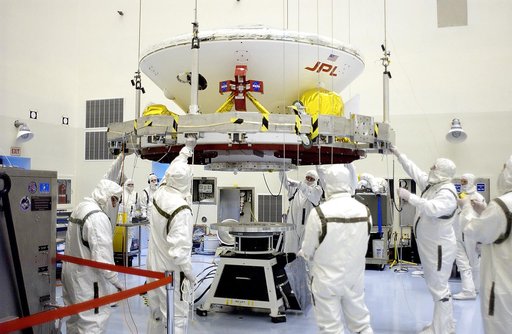 KENNEDY SPACE CENTER, FLA. - In the Payload Hazardous Servicing Facility, the Mars Exploration Rover 2 (MER-2) is lowered toward the spin table.  NASA’s twin Mars Exploration Rovers are designed to study the history of water on Mars. These robotic geologists are equipped with a robotic arm, a drilli