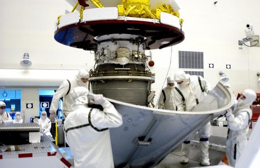 KENNEDY SPACE CENTER, FLA. -  Workers in the Payload Hazardous Servicing Facility place the lower sections of the transport canister around the Mars Exploration Rover 2 (MER-2).  After encapsulation, it will be transferred to Launch Complex 17-A, Cape Canaveral Air Force Station.  MER-2 is one of NA