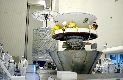 KENNEDY SPACE CENTER, FLA. - In the Payload Hazardous Servicing Facility, an overhead crane (background) begins to lift the canister that will complete encapsulation of the Mars Exploration Rover 2 (MER-2) in the foreground.  After encapsulation, MER-2 will be transferred to Launch Complex 17-A, Cap