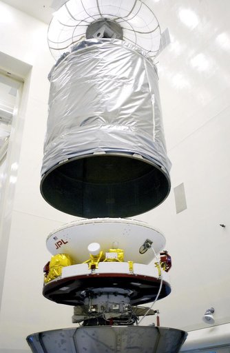 KENNEDY SPACE CENTER, FLA. - In the Payload Hazardous Servicing Facility, an overhead crane lowers the canister that will complete encapsulation of the Mars Exploration Rover 2 (MER-2), at right.  After encapsulation, MER-2 will be transferred to Launch Complex 17-A, Cape Canaveral Air Force Station