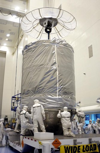 KENNEDY SPACE CENTER, FLA. - In the Payload Hazardous Servicing Facility, an overhead crane lowers the canister that will complete encapsulation of the Mars Exploration Rover 2 (MER-2), at right.  After encapsulation, MER-2 will be transferred to Launch Complex 17-A, Cape Canaveral Air Force Station