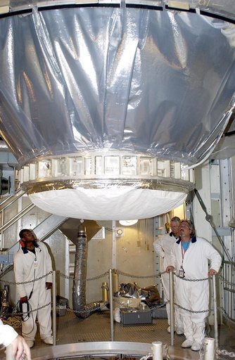 KENNEDY SPACE CENTER, FLA. -  On Launch Pad 17-A, Cape Canaveral Air Force Station,  workers watch as the Mars Exploration Rover 2 (MER-2), inside the transport canister, is lowered toward the Delta II rocket for mating.  MER-2 is one of NASA's twin Mars Exploration Rovers designed to study the hist