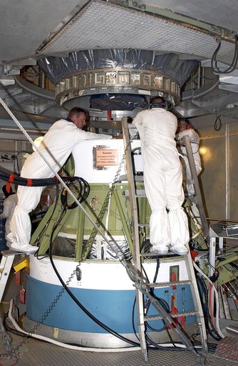 KENNEDY SPACE CENTER, FLA. - On Launch Pad 17-A, Cape Canaveral Air Force Station,  workers attach the Mars Exploration Rover 2 (MER-2) , above, to the second stage of the Delta II rocket, below.  MER-2 is one of NASA's twin Mars Exploration Rovers designed to study the history of water on Mars. The