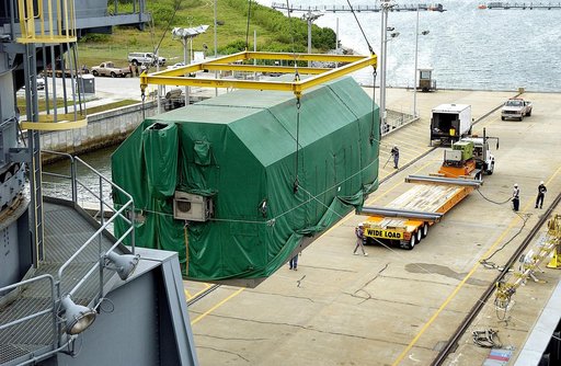 KENNEDY SPACE CENTER, FLA. - At Port Canaveral, the Pressurized Module of the Japanese Experiment Module (JEM) is lifted out of the ship’s cargo hold.  It will be loaded onto the truck bed in the background for transfer to KSC’s Space Station Processing Facility.  The container transport ship carryi